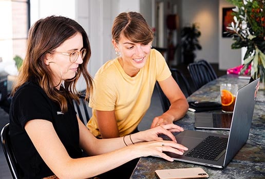 Two female professionals collaborating at a computer